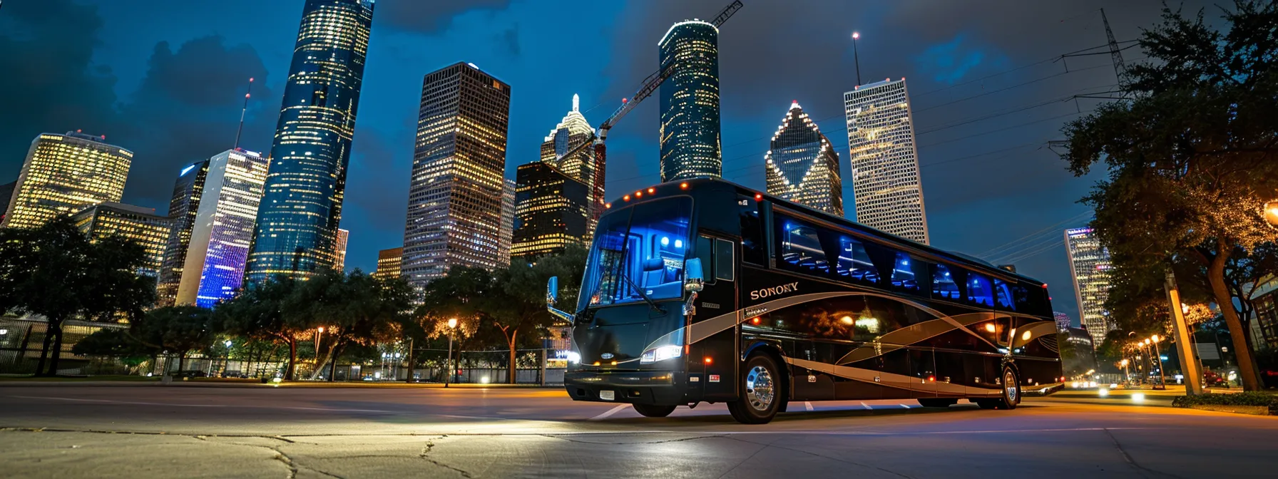 luxury charter bus parked in front of houston's iconic landmarks.